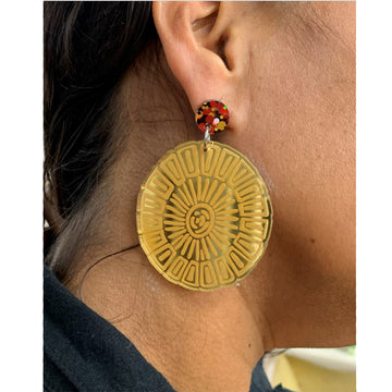 A pair of stud earrings with a round colourful stud attached to a large gold mirror disc on a card.