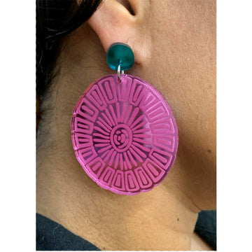 A pair of stud drop earrings with a navy circle stud attached to a large pink mirror disc on a card.