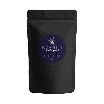 A black packet with a round dark blue label on the front with the text 'Warndu Feel Good Pepper Berry'.