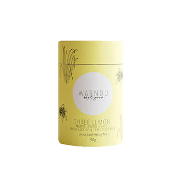 A yellow canister with a round white label on the front with the text 'Warndu Feel Good Three Lemon Native Lemon Grass Lemon Myrtle ad Lemon Verbena'.