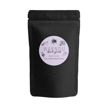 A black packet with a light purple round label on the front with the text 'Warndu Feel Good Wild Chai'.