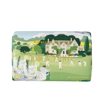 A bar of soap wrapped in packaging illustrated with two gin and tonics on a table overlooking a game of cricket.