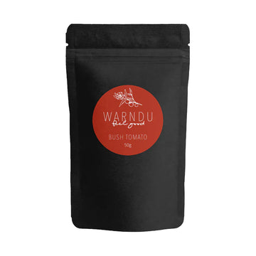 A black packet with a red circle label on the front with the text 'Warndu Feel Good Bush Tomato'.