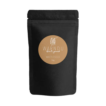 A black packet with a light brown round label and the text 'Warndu Feel Good Wattleseed'.
