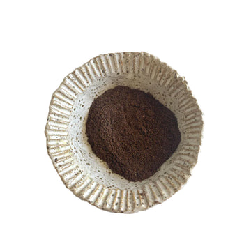 A black packet with a light brown round label and the text 'Warndu Feel Good Wattleseed'.