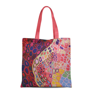 A tote bag with coral pink handles and printed with artwork by Amanda Jane Gabori.