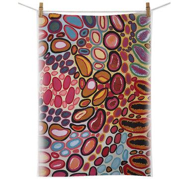 A cotton tea towel printed with artwork by Dorothy Gabori is hanging from a white cord with pegs.