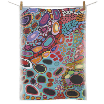 A tea towel printed with artwork by Dorothy Gabori is hanging from a white cord with pegs.