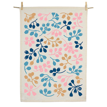 A cotton tea towel printed with colourful gumnuts and hanging from a rope with pegs.