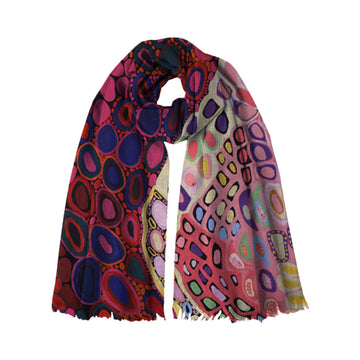 A modal scarf printed with artwork by Amanda Jane Gabori is wrapped up like its being worn.