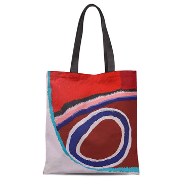 A tote bag with black straps printed with artwork in red, black and blue.