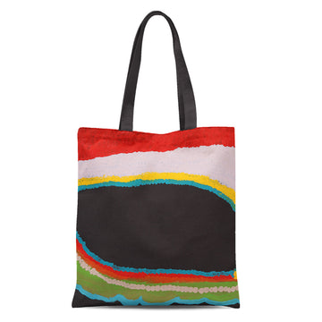 A tote bag with black straps printed with artwork in red, yellow, green and black.