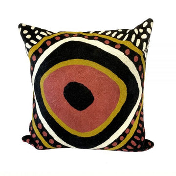 Woven woollen, zippered cushion cover 40cm x 40cm, cotton base. Artwork by Nina Puruntatameri. Black background and centre. Large concentric circle white, red ochre, yellow ochre.