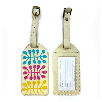 Two leather luggage tags pictured. One has an embroidered design by Mitjili Napurrula and the other has a blank address label.