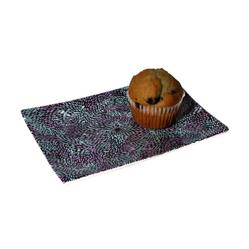 A small rectangle ceramic tray printed with artwork by Daphne Napurrula Marks in blue and purple.