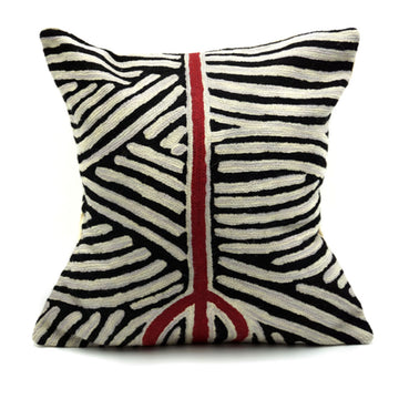 A black and white cushion with stripes going in different directions. There is a red stripe through the middle. Artwork by Valda Napangardi Granites.