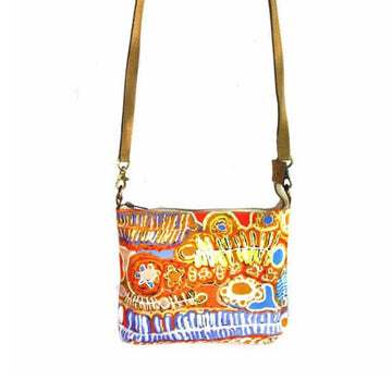 Cross body leather trimmed bag, 24.5cm x 20cm with original artwork by Murdie Morris. Natural leather strap, metal clips, rings, zip. Orange background, blue, yellow, white embroidered indigenous motifs.