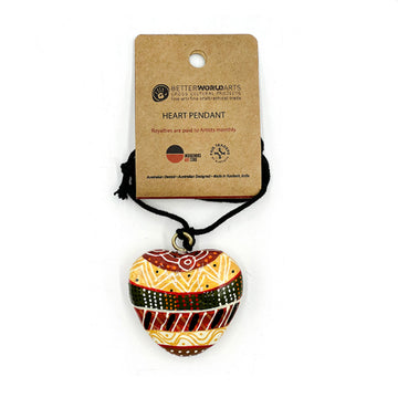 A heart shaped pendant printed with artwork by Josette Papajua on a black cord attached to a brown information card.