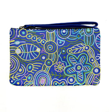 A small clutch embroidered with flowers and symbols on a blue background with a matching blue wrist strap on the zip along the top.