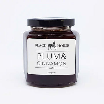 A clear jar with a white product label and a black lid. The label says 'Black horse Plum & Cinnamon Jam' with a image of a horse at the top. The jam can be seen through the jar.