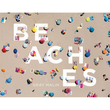 'Beaches' book cover featuring a top down view of a beach filled with people and different coloured umbrellas.