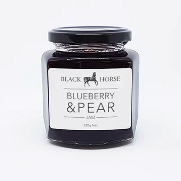 A clear jar with a black lid and white product label. The label says 'Black Horse Blueberry & Pear Jam' with an image of a horse at the top. The jam can be seen through the clear jar.