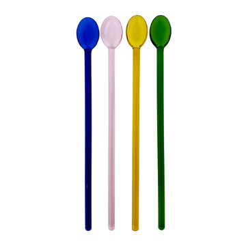 Four different coloured spoons with long handles against a white background.