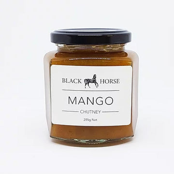 A clear jar with a black lid and white product label. The label says 'Black Horse Mango Chutney' with an image of a horse. The chutney can be seen through the jar.