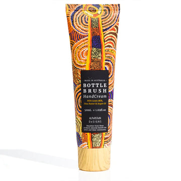 A small tube of hand cream with artwork by Nora Nyutjangka Davidson on the front with a black product label and wood look lid.
