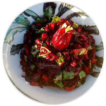Gleaming black glass jar and metal lid, black label with red hibiscus flower and bubbles. Wild hibiscus flowers in syrup in yellow type, tamper proof tab.