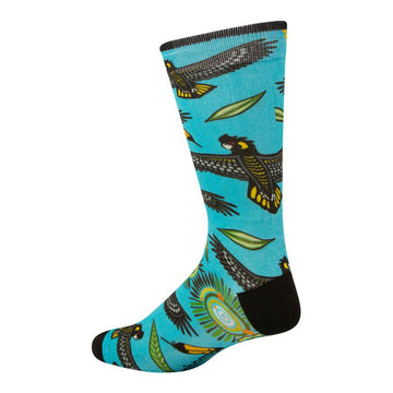 Side view of bamboo blend sock featuring indigenous artwork by Nathan Patterson. Black cockatoo with yellow feathers in flight, wings spread; leaves; indigenous motif. Bright turquoise sock, black toe, heal.
