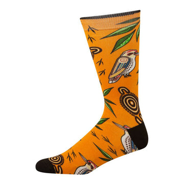 Side view of bamboo blend sock featuring indigenous artwork by Nathan Patterson. Side view of kookaburra, green leaves, and indigenous motifs. Orange sock with black heal and toe.