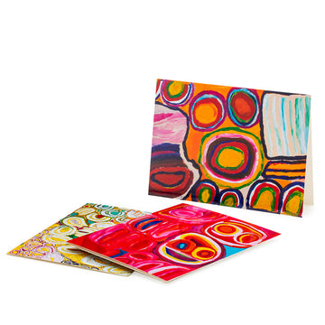 Card pack, gift boxed, containing twelve blank cards and envelopes. Brightly coloured circles and shapes on box with orange background. Box is open with an assortment of cards displayed.