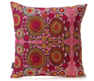 Cushion featuring artwork by Teddy Gibson made up of red, yellow, black and white circles with a dot design.