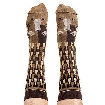 A pair of knee high socks being worn with platypus faces and features on them.