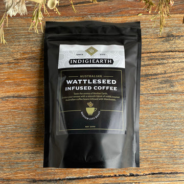 A black packet with a large product label on the front. The label says 'Indigiearth Australian Wattleseed Infused Coffee' with product details written underneath.