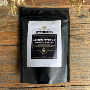 A black packet with a large product label on the front. The label says 'Indigiearth Australian Lemon Myrtle Infused Coffee' with extra product information below.
