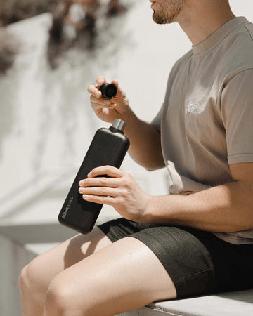 A tall black stainless steel water bottle with the text 'memobottle' on the bottom left.