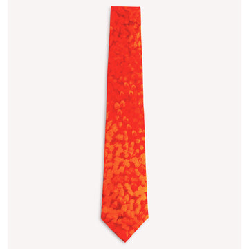A tie in orange with lighter orange spots on top. Artwork by Muuki Taylor.
