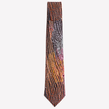 A tie featuring artwork by Minyawe Miller in black, yellow and orange.