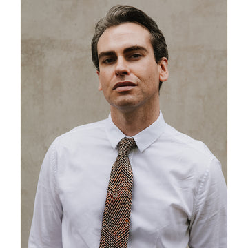 A tie featuring brown, black and orange artwork by Phyllis Donegan.