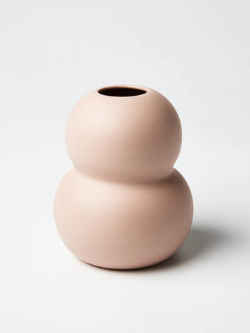 A ceramic vase in light pink with a double rounded shape.