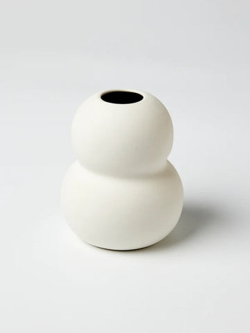 A small white vase with a double rounded shape.