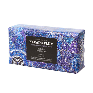 Body Bar wrapped in blue and white dot art coloured paper, featuring artwork by Warlukurlangu Artist Alma Granites. Kakadu Plum written in white text on black square. Made in Australia.