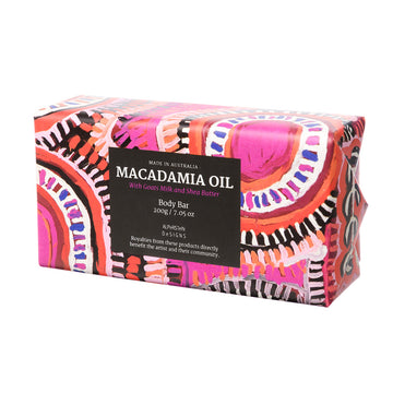Body bar wrapped in vibrant, brightly coloured paper featuring the artwork of Warlukurlangu Artist Murdie Morris. Macadamia Oil written in white text on a black square. Made in Australia.