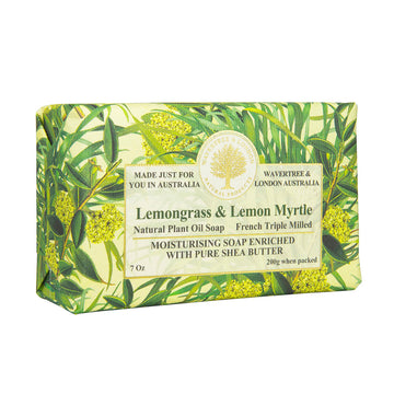Image shows a slight side of a bar of soap laden with green leaves and blossoms. The label on the front is the very lightof green with text "Lemongrass & Lemon Myrtle".