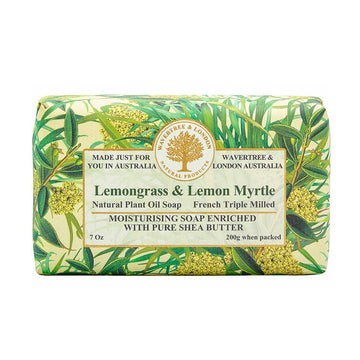 Image shows a slight side of a bar of soap laden with green leaves and blossoms. The label on the front is the very lightof green with text "Lemongrass & Lemon Myrtle".