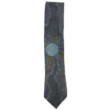 Australian made polyester printed tie. Artwork, Fire & Water Dreaming, by Maureen Hudson. Purple, grey, ochre patches, and dot art; light blue circles in centre.