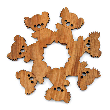 A wooden trivet featuring cut out koalas sitting next to each other to form one shape.